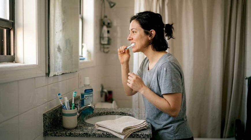Adult brushing teeth in home bathroom