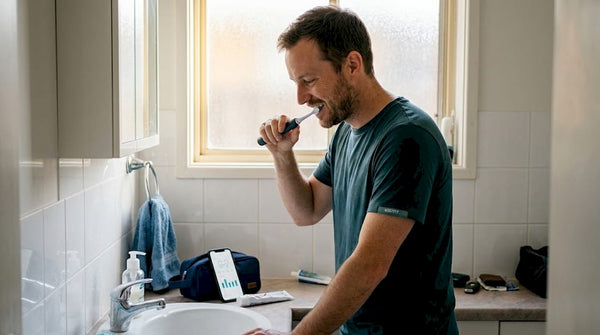 Man brushing teeth using smart toothbrush app