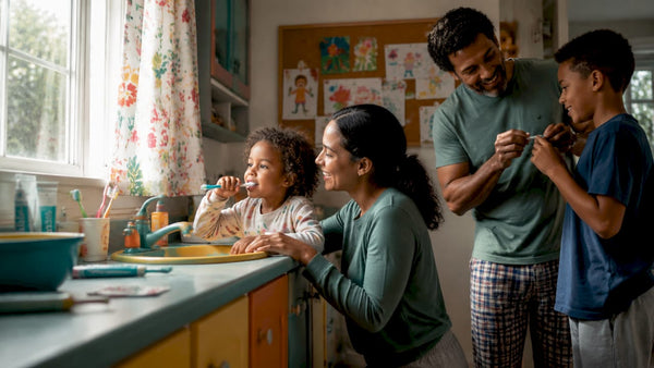 Family brushing teeth together in bathroom