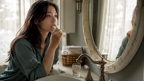 Busy woman brushing teeth in modern bathroom