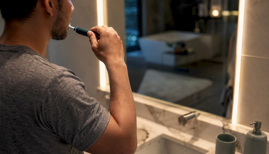 Close-up of hand brushing teeth with electric toothbrush