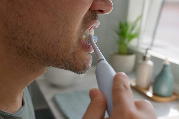 Close-up of gentle gum brushing with sonic toothbrush