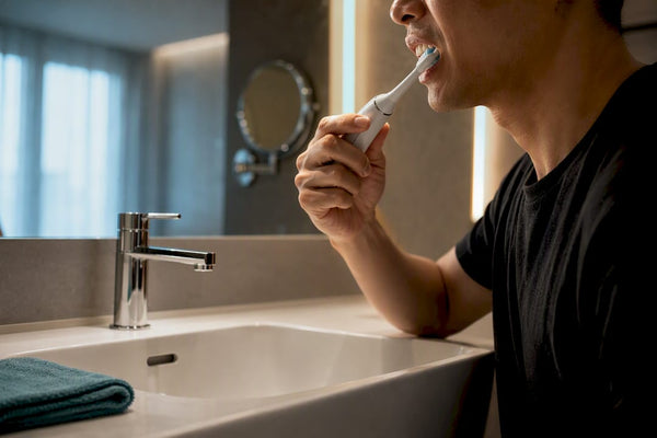 Adult gently guiding powered toothbrush